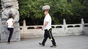 صيني يحمل حجراً على رأسه ليخسر الوزن الزائد !