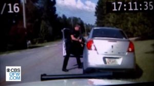 بالفيديو .. سائقة أمريكية تهرب من شرطي حاول اعتقالها