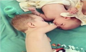 بالفيديو .. طفل بدون ذراعين يساعد أخاه الرضيع