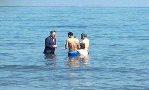 تركيا : مرشح برلماني يمشي داخل البحر بلباسه الرسمي ليطلب من المصطافين التصويت له ! ( فيديو )