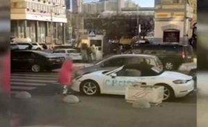 فتاة تحطم سيارة ” بورش ” بالفأس وسط العاصمة كييف ( فيديو )