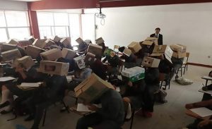 معلم مكسيكي يغطي رؤوس طلابه بـ ” صناديق كرتونية ” لمنع الغش بالامتحان !