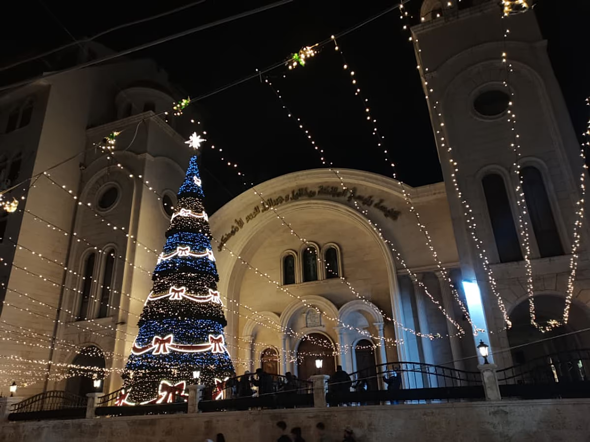 يورونيوز: ” عيد الميلاد في سوريا .. احتفالات حذرة وأضواء خافتة بدمشق تتناقض مع فرحة الشمال واللاذقية “ – عكس السير